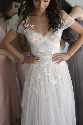 Elegant white wedding dress featuring intricate floral lace embroidery, strapless sweetheart neckline, and a floor-length ball gown design, ideal for a romantic bridal style