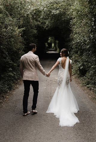 Elegant ivory bridal gown featuring intricate floral embroidery, off-the-shoulder sweetheart neckline, and flowing A-line tulle design, ideal for classic and magical wedding celebrations