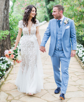 Romantic ivory wedding dress adorned with 3D floral lace detailing, sweetheart neckline, off-the-shoulder design, and a flowing tulle ball gown, perfect for a fairy-tale bridal look