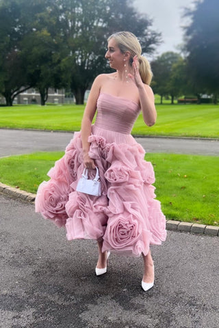 Whimsical pink dress with a structured strapless top and textured floral accents, blending timeless elegance with contemporary charm for special celebrations