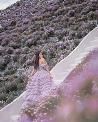 The voluminous tiered skirt creates a dramatic and romantic silhouette, perfect for whimsical garden settings