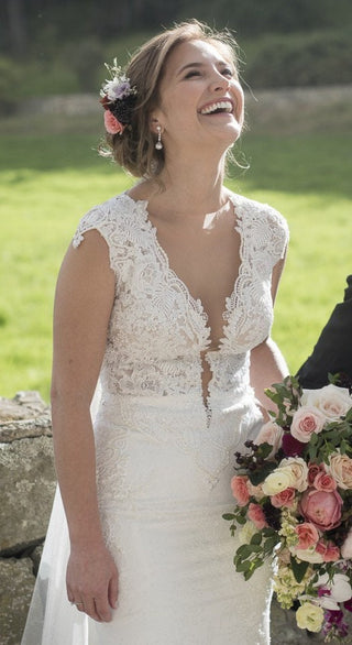 Beautifully crafted bridal gown showcasing refined lace detailing and a scalloped train, ideal for brides who love classic elegance and a touch of glamour