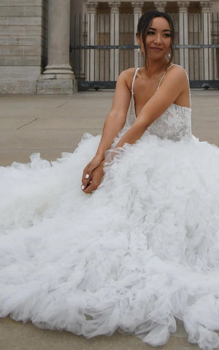 Bride in a stunning ballgown wedding dress with intricate lace detailing and romantic fluffy ruffles