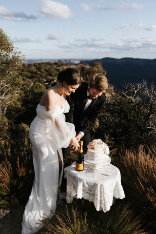 Sophisticated wedding dress with sheer billowing sleeves, a figure-hugging fit, and a clean design, creating a romantic yet contemporary look for garden ceremonies