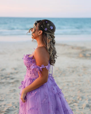 The dress showcases a beautiful sweetheart neckline that complements the soft, flowing silhouette of the tulle fabric. The vibrant lavender hue evokes a dreamy, soft pastel vibe, making it ideal for spring or summer celebrations. The lightweight material ensures comfort and fluid movement, making this gown both practical and elegant for outdoor events like garden parties or beach weddings.