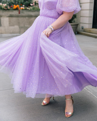 Pastel purple glittery dress with soft puff sleeves and a voluminous silhouette, exuding charm and femininity for formal or festive occasions.