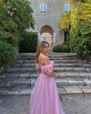 Ethereal pink tulle gown with floral off-the-shoulder straps and a cinched waist, designed for elegant weddings and fairy-tale-inspired occasions