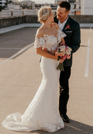 Ivory princess bridal ball gown with intricate 3D floral lace applique, sweetheart neckline, off-the-shoulder design, and flowing tulle A-line silhouette, perfect for elegant fairy-tale weddings