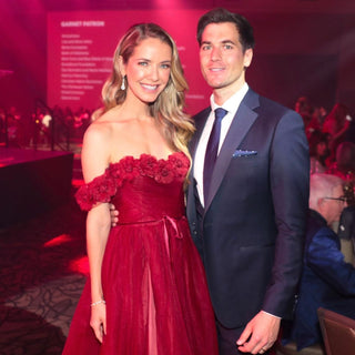 Elegant deep red gown featuring an off-the-shoulder neckline adorned with floral embellishments, perfect for formal evening events.