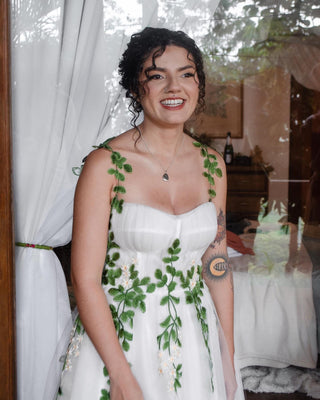 Whimsical white tulle gown with green leaf embroidery and delicate floral detailing, a perfect choice for nature-inspired weddings