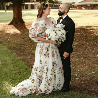 Elegant embroidered bridal gown featuring a floral pattern, off-the-shoulder puff sleeves, and a flowing A-line silhouette, ideal for fairy-tale-inspired wedding occasions