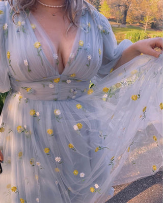 Sophisticated light blue tulle dress with yellow daisy floral accents, puff sleeves, and a flattering A-line silhouette, designed for modern and enchanting outdoor occasions