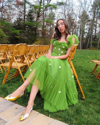 Whimsical green dress with playful floral accents, sheer overlay, and a flattering A-line silhouette, styled with delicate ruffled straps, ideal for outdoor events or casual weddings