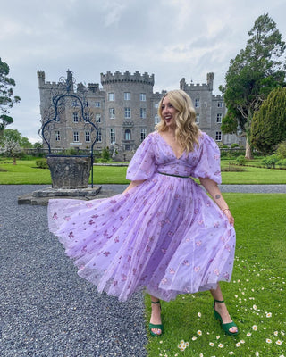 Dreamy lavender gown adorned with pink flower details and ethereal puff sleeves, offering a whimsical and enchanting aesthetic