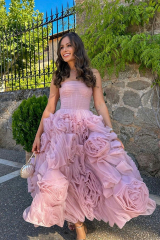 Romantic blush pink dress featuring a strapless bodice and a voluminous skirt adorned with oversized rosette details, ideal for garden parties or whimsical weddings