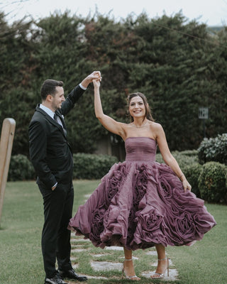 Strapless purple cocktail dress with dramatic ruffled floral tulle detailing, A-line silhouette, and knee-length design, perfect for formal events and special celebrations