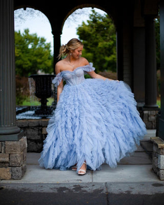 Romantic light blue gown featuring a voluminous textured skirt, off-shoulder detailing, and intricate boned bodice, embodying a fairy-tale aesthetic.

