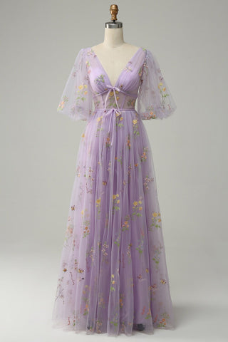 This enchanting lilac floral gown features intricate embroidered details, bringing a sense of whimsy and elegance. The dress is adorned with colourful flowers and butterflies, creating a soft, ethereal vibe perfect for spring or summer events. The delicate floral design is intricately embroidered into the sheer tulle fabric, making it an ideal choice for anyone looking for a romantic, bohemian-inspired look.