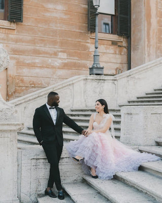 Romantic ivory off-the-shoulder tulle ball gown adorned with layered frill detailing and a sweetheart neckline, perfect for magical fairy-tale-inspired wedding ceremonies