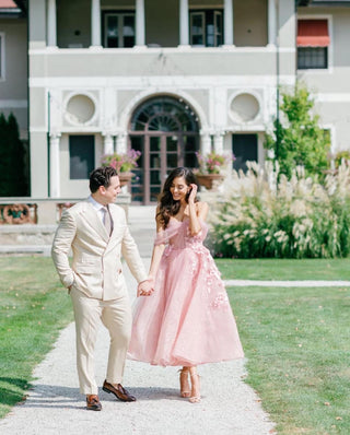 Elegant blush midi dress with intricate floral embellishments, a structured bodice, and flowing tulle layers, creating a charming look for bridal showers or formal gatherings