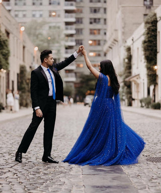 Romantic cobalt blue and gold starry ball gown, features a sweetheart neckline, long cape sleeves, and floor-length glitter A-line silhouette, perfect for celestial-themed weddings and special occasions