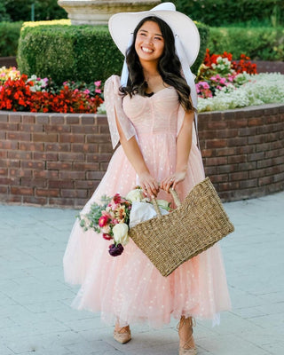 Elegant pink sparkle dress featuring layered tulle, sweetheart neckline, and a flowy tea-length design, styled with a cowboy hat, ideal for modern fairycore or boho-inspired occasions