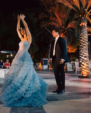 A dreamy tiered ball gown featuring cascading layers of soft blue tulle for a voluminous and elegant look