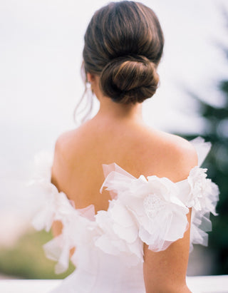 Elegant bridal dress with delicate floral detailing on the neckline, a fitted top, and a flowing silhouette perfect for a timeless wedding look