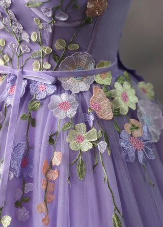 Elegant purple evening dress featuring a corset-style bodice adorned with delicate 3D flowers and a voluminous tulle skirt