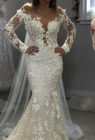 Elegant ivory bridal dress featuring intricate floral embroidery, deep V-plunge neckline, sheer puff off-the-shoulder sleeves, and mermaid fit-and-flare design, ideal for glamorous and modern weddings