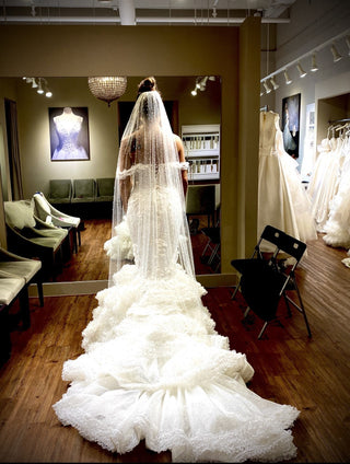 Chic mermaid wedding dress with 3D floral lace accents, sequins, and an off-the-shoulder neckline, complemented by a dramatic train for an elegant and romantic bridal style