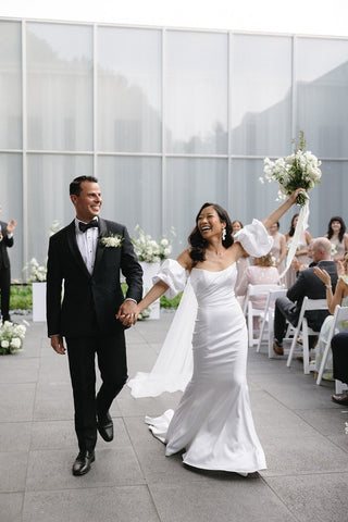 Sophisticated ivory satin wedding dress with a strapless neckline, sleek mermaid silhouette, and flowing floor-length design, ideal for glamorous bridal occasions