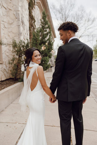 Elegant and minimalistic wedding dress paired with a radiant smile and a classic white bouquet for a fresh bridal style