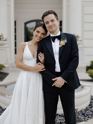 Chic ivory wedding dress with a plunging neckline, minimalist sleeveless design, and a voluminous A-line skirt, tailored for contemporary and romantic bridal styles