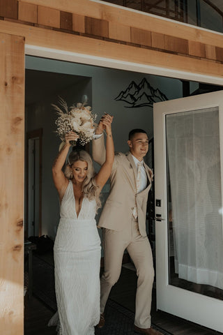 Beautiful bride wearing a deep V-neck lace gown, styled with soft waves and a delicate pendant necklace