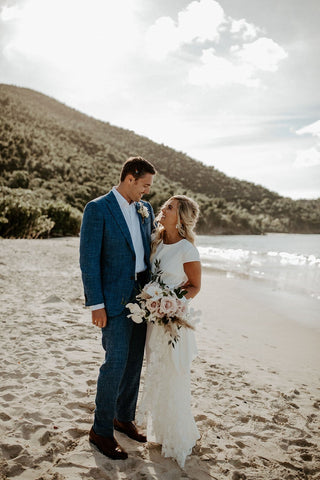 Romantic ivory dress with a cap-sleeve bodice, high-low skirt, and cinched waist, perfect for rustic, bohemian, and outdoor wedding celebrations