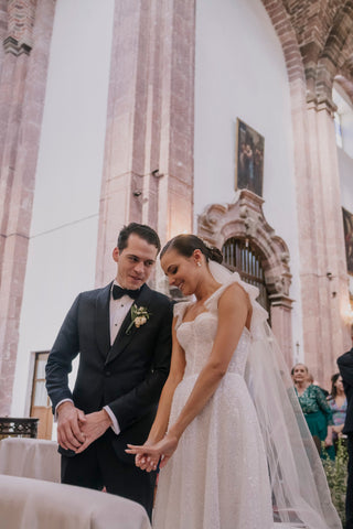 Stylish wedding dress with sparkle-embellished fabric and fitted bodice, paired with ethereal veil for a contemporary bridal look