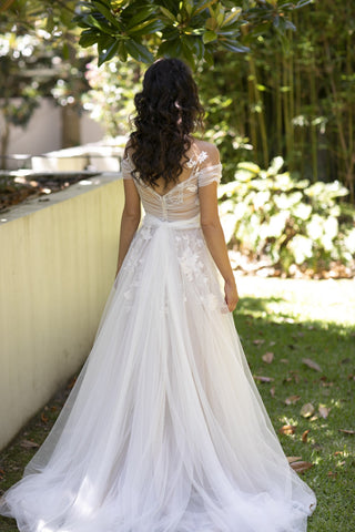 Chic white bridal ball gown with floral applique, strapless sweetheart neckline, and flowing tulle A-line silhouette, tailored for modern and classic wedding aesthetics