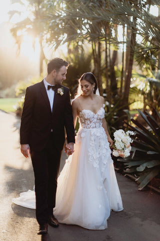 Romantic ivory tulle bridal gown, adorned with 3D floral lace applique, sweetheart neckline, and thin straps, perfect for boho-chic brides and magical wedding celebrations