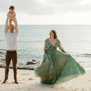 Elegant green floral gown featuring delicate embroidered flowers, a flowing tulle skirt, and a deep V-neckline, perfect for a whimsical beachside celebration or a romantic photoshoot