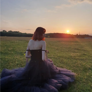 Charming strapless navy gown with embroidered cherries, sheer tie-up straps, and voluminous tulle layers, ideal for summer weddings