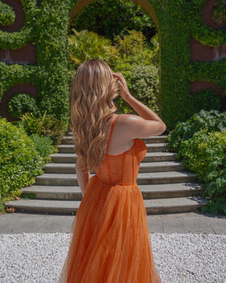 Captivating burnt orange ballgown with a strapless corset design, delicate lace overlay, and layered tulle skirt, ideal for autumn weddings or formal occasions