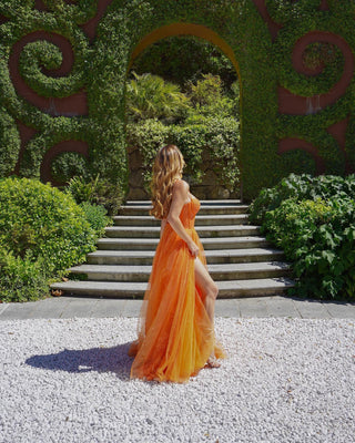 Unique tangerine-hued gown showcasing intricate lace embroidery, a flattering sweetheart neckline, and a full tulle skirt for a vibrant and elegant appearance