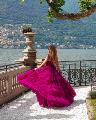 Chic fuchsia A-line dress with dramatic ruffled tulle design, thin straps, and a floor-length silhouette, tailored for sophisticated and fashionable events