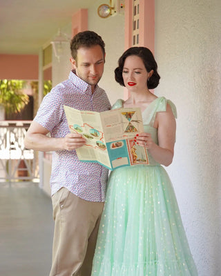 Charming light green dress featuring sheer layers of dotted tulle, a fitted bodice with bow-tied straps, and a flowy silhouette, ideal for casual daytime gatherings or fairy-tale inspired celebrations