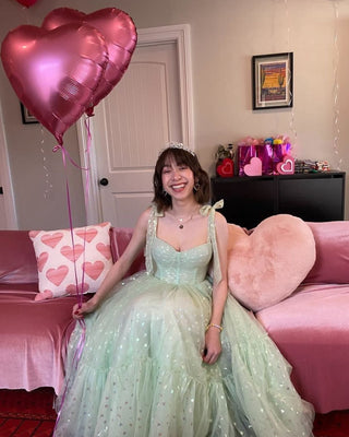 Romantic mint green gown with a structured sweetheart bodice, dainty polka dot embellishments, and a tiered A-line skirt, styled with playful sneakers for a modern and relaxed look