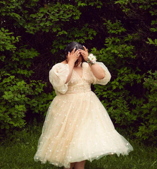 Cream yellow ball gown with daisy floral embroidery, deep V-neckline, half puff sleeves, and a midi tea-length tulle silhouette, perfect for formal events, proms, and cottagecore-themed weddings