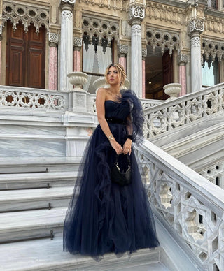 Sophisticated navy evening dress with voluminous tulle and an asymmetrical one-shoulder style, embodying modern elegance