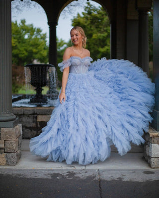 Ethereal blue tulle dress with dramatic cascading ruffles and a fitted sweetheart corset, perfect for elegant photoshoots or special occasions.