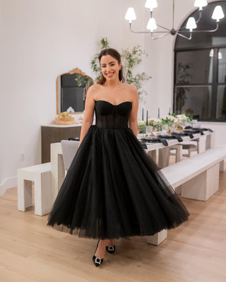 Black pleated tulle ball gown, strapless A-line prom dress, tea-length design, featuring a whimsical corset and gothic fairycore aesthetic, perfect for formal evening occasions